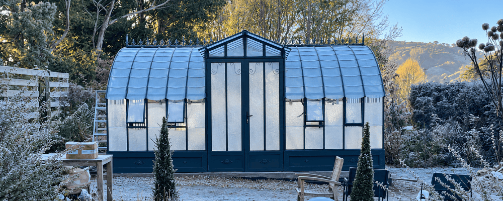 Serre Amboise LAMS de 5,60 × 5,30 m sur embase de 40 cm, dans un jardin en hiver.